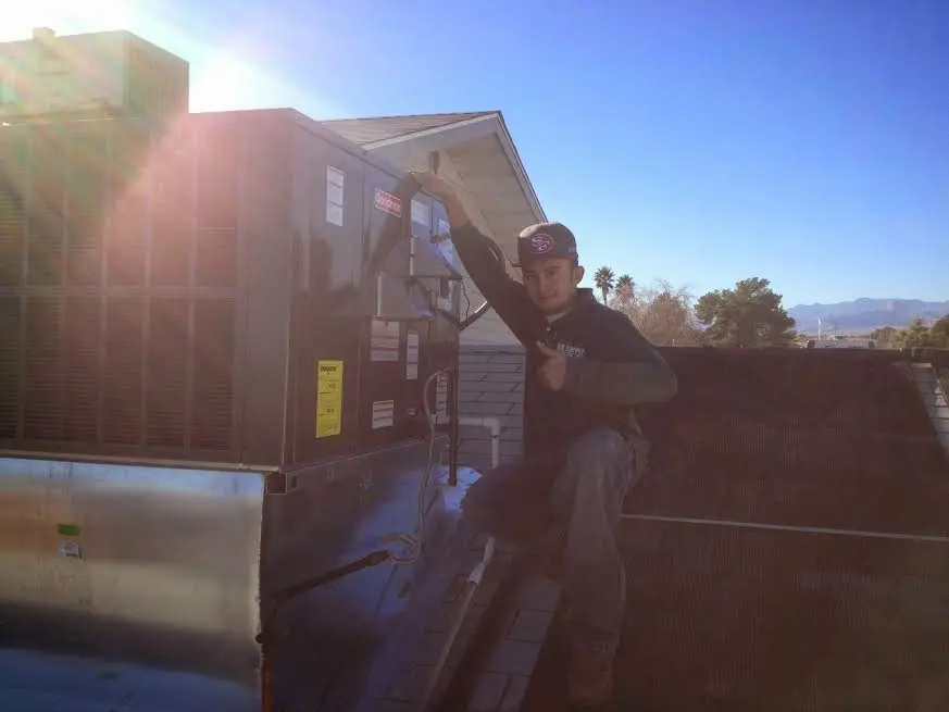 HVAC technician performing AC Tune-Up on a rooftop unit in Crosspointe